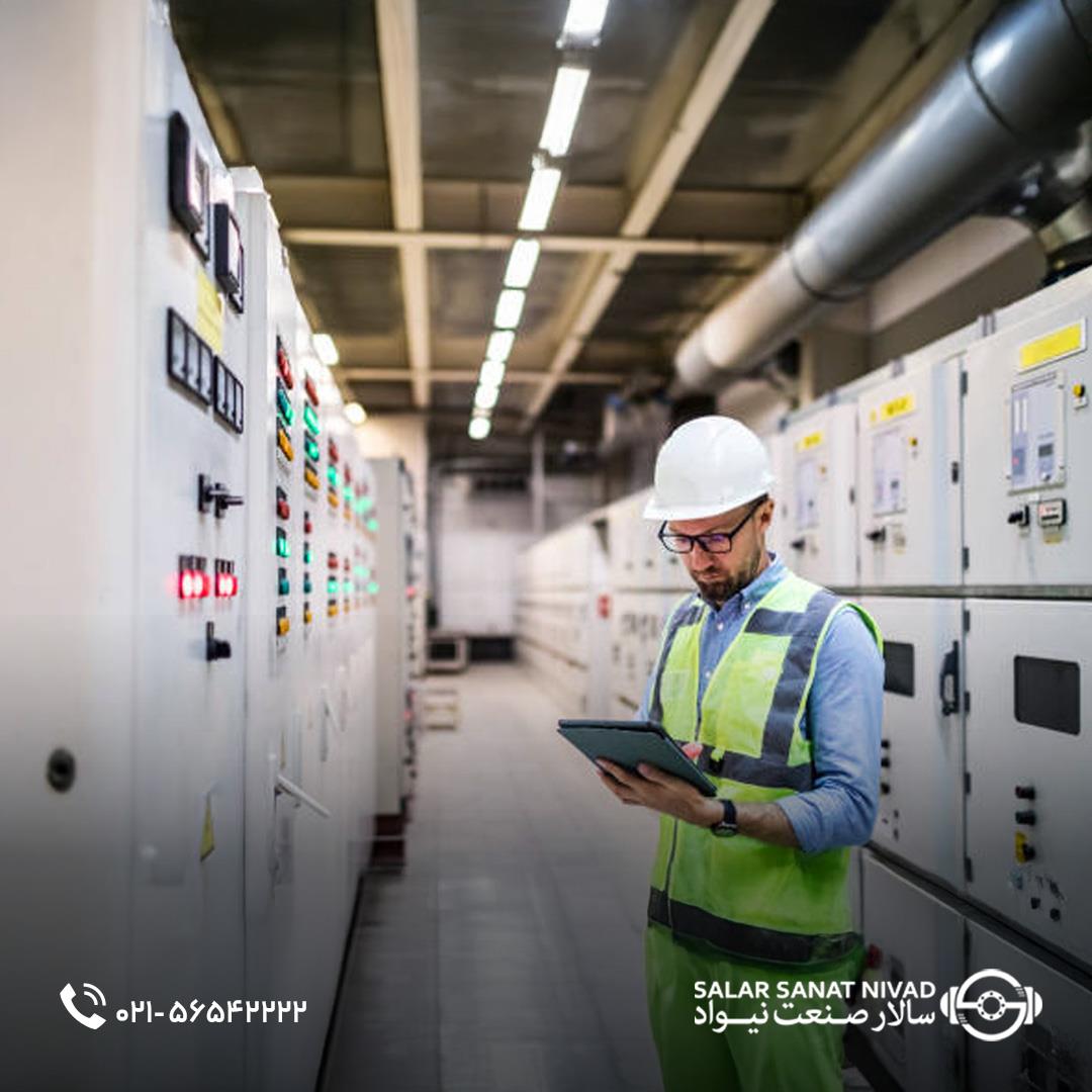 تکنسین در حال بررسی تابلو برق صنعتی