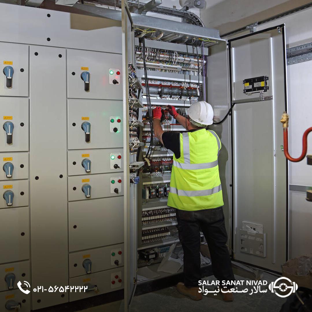 تکنسین برق در حال بازرسی تابلو برق صنعتی